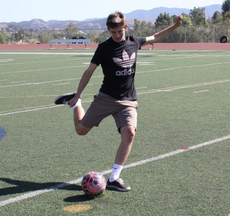Junior Nick Cruz kicks a soccer ball while practicing. He was affected by the new age group change made this year (Meghana Mudunuri/Talon).