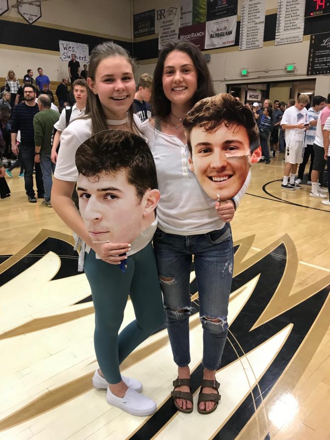 +Lauren+Bowman+and+Harper+Wayne+pose+with+head+cutouts+of+varsity+basketball+players+Riley+Battin+and+Wes+Slajchert.+
