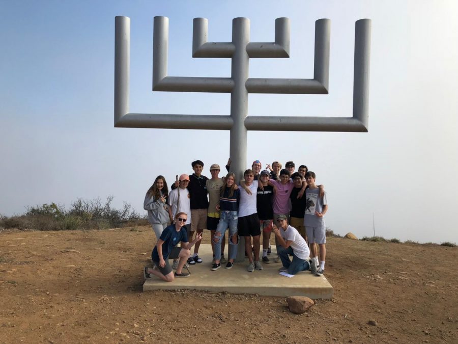 Students+gather+around+the+menorah%2C+which+stills+stands+after+the+campsite+burned+in+Malibu+during+the+Woolsey+Fire