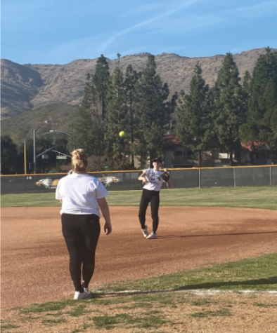 Senior co captains Aubrey Billig and Havi Rubenfeld warm up together in preparation for upcoming softball games.