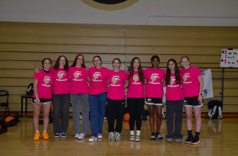 The whole team gathers for a picture, before going to watch the last football game of the season after practice. All of them wear a pink basketball shirt to show support for Breast Cancer Awareness Month. Left to Right: White, Deshautelle, Mckenna Ireland, West, Maddie Woodger, Alex Nelson, Bommareddy, Ava Rogerson, Broms.