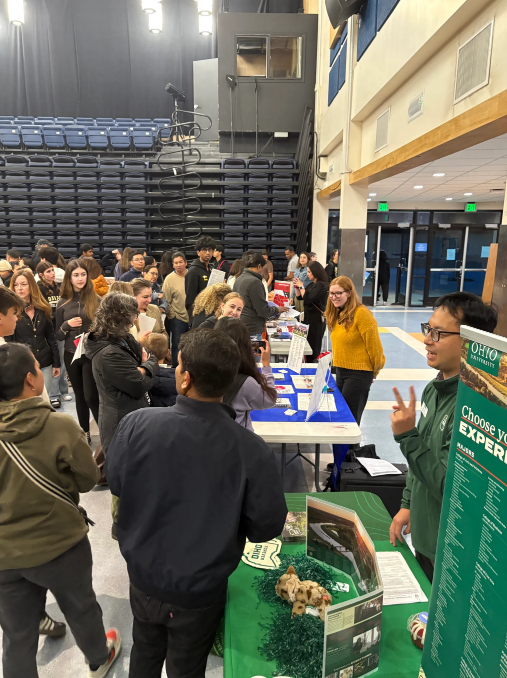 Students line up to talk to representatives at a college fair in the Pavilion